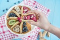 Female hand holds a pancake with raspberries. Classic American pancakes with fresh fruits. Summer homemade breakfast. Copy space.