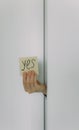 female hand holds a piece of paper with a sign Yes and No. Choice and question answer concept Royalty Free Stock Photo