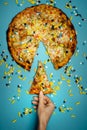 Female Hand Holds In Hand A Piece Of Pizza Sprinkled With Pills, Top view Idea. Biohacking Healthy Food Concept