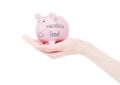 Female hand holds piggy bank vacation fund concept