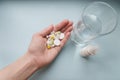 Female hand holds pills of many different colors on a blue background Royalty Free Stock Photo