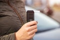 Female Hand Holds Portable Alcometer With Display. Checking Sobriety Next To Automobile. Copy space for text Royalty Free Stock Photo