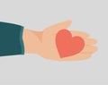 Female hand holds a red heart to celebrate Valentines day. Concept of love confession