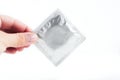 Female hand holds a silver condom Royalty Free Stock Photo