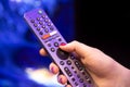Female hand holds a smart TV remote control with microphone and voice control. background in blur. soft focus Royalty Free Stock Photo