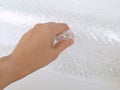 Female hand holds transparent bubble wrap for packaging fragile items, close up