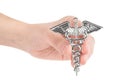 Female hand holds a two-snake design Hermes symbol. Caduceus as a symbol of medicine. Close-up shot, isolated on white