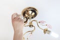 Female hand inserts a light bulb into the threaded socket. she is shining. Installation of household LED lamps of corn type, in Royalty Free Stock Photo