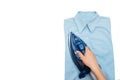 Female hand ironing clothes top view isolated on white background. Young woman with iron ironing man`s shirt seen from above Royalty Free Stock Photo