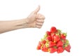 Female hand isolated on white background with bright red fresh strawberry pile or heap. The thumb up. Crop or food quality concept