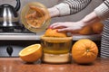 Female hand Juicing oranges. Closeup on womenÃ¢â¬â¢s hand making orange juice. Squeezing orange juice