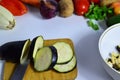 Female hand with knife cuts eggplant on board in kitchen. Cooking vegetables. to make a vegetable stew or salad Royalty Free Stock Photo