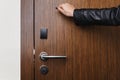 Hand knocking on hotel door with electronic lock Royalty Free Stock Photo