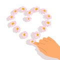A female hand laid out a heart of daisies. Beautiful simple pink flowers. Love concept. Self love. frame of flowers. For