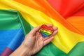 Female hand LGBT heart on LGBT flag background