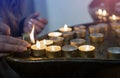 Female hand lighting candles in the chapel Royalty Free Stock Photo