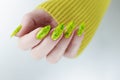 Female hand with long nails and a bright yellow green neon manicure Royalty Free Stock Photo