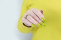 Female hand with long nails and a bright yellow green neon manicure Royalty Free Stock Photo