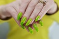Female hand with long nails and a bright yellow green neon manicure Royalty Free Stock Photo