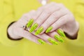 Female hand with long nails and a bright yellow green neon manicure Royalty Free Stock Photo