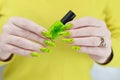 Female hand with long nails and a bright yellow green neon manicure Royalty Free Stock Photo