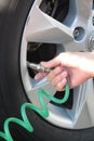 Female hand filling car tire with air pump vertical Royalty Free Stock Photo