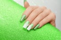 Female hand with long nails with glitter nail polish. Long green nail design. Women hand with sparkle manicure on glitter Royalty Free Stock Photo