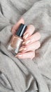 Female hand with long nails holds a bottle nail polish Royalty Free Stock Photo