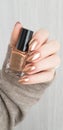 Female hand with long nails holds a bottle nail polish Royalty Free Stock Photo