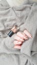 Female hand with long nails holds a bottle nail polish Royalty Free Stock Photo