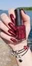 Female hand with long nails holds a bottle nail polish Royalty Free Stock Photo