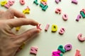 female hand makes the word kids from wooden multicolored letters. educational games. selective focus