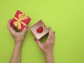 female hand manicure, gift box heart on colored background