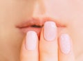 Female hand with manicure near lips, close-up. Royalty Free Stock Photo