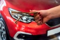 female hand with manicured red nails holds a large amount of euro banknotes near the car Royalty Free Stock Photo