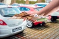 female hand with manicured red nails holds a large amount of euro banknotes near the car Royalty Free Stock Photo