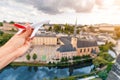 hand with a model aircraft on the background of the sights of Luxembourg. Concept of airline and air transport