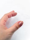 A female hand with nail peeling problem on the white background.