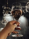 Female hand with a neat manicure holds glass of champagne. Woman raises high goblet of sparkling wine Royalty Free Stock Photo