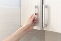 Female hand open the cupboard doors, close up. Royalty Free Stock Photo