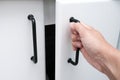 Female hand open white kitchen cabinet,cupboard doors, close up Royalty Free Stock Photo