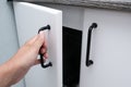 Female hand open white kitchen cabinet,cupboard doors, close up Royalty Free Stock Photo