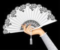Female hand with open white vintage fan isolated on black background Royalty Free Stock Photo