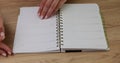 Female hand opening blank notepad page hand