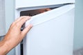 Female hand opening a fridge door, check up reserves and food freshness Royalty Free Stock Photo