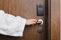 Female hand opening hotel room door knob Royalty Free Stock Photo