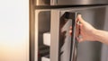 Female hand opening a refrigerator door for find the food and ingredient preparing to cooking in their home Royalty Free Stock Photo