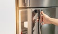 Female hand opening a refrigerator door for find the food and ingredient preparing to cooking in their home Royalty Free Stock Photo