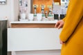 Female hand opening a white drawer of a sink in a store