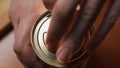 Female hand opens jar with preserved green olives for cooking tasty dishes